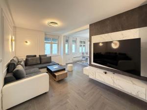 a living room with a couch and a large television at Skadarlija Soul in Želenička Stanica Beograd Sava