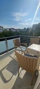 a balcony with two chairs and a table on a balcony at Apartmani Katarina in Rogoznica