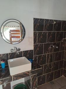 ein Badezimmer mit Waschbecken und Spiegel in der Unterkunft Mango Eden Hotel in Nosy Be + 25 Fotos
