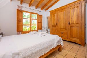 a bedroom with a white bed and a wooden cabinet at Ses Planes -Ca Na Faustina- in Selva +25 photos