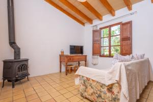 a living room with a wood stove and a desk at Ses Planes -Ca Na Faustina- in Selva