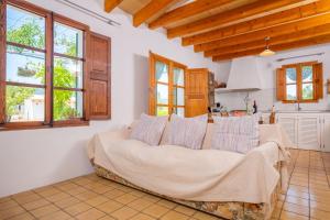 a living room with a couch and a kitchen at Ses Planes -Ca Na Faustina- in Selva