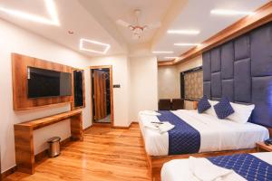 a hotel room with a bed and a flat screen tv at Hotel Prince Palace in Mumbai
