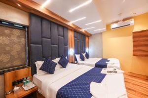 two beds in a hotel room with blue and white at Hotel Prince Palace in Mumbai