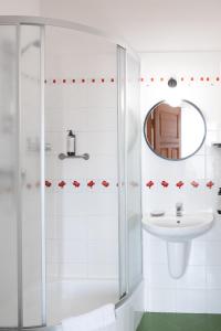 a white bathroom with a shower and a sink at Mleczarnia Hotel Restauracja in Chludowo +47 photos