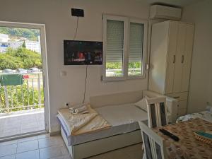 a room with a bed and a table and a window at Guest House Levant in Čanj