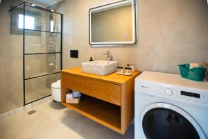 a bathroom with a sink and a washing machine at Mediterranean Blue Suites & Villa - Blue Horizon Suite in Tympáki +16 photos