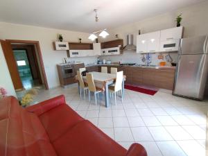a kitchen and dining room with a red couch and a table at Il Posto Giusto 2 punto 0 in Messina