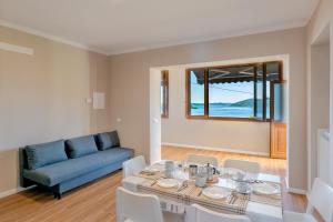 a living room with a table and a blue couch at Casa 24 - Trilocale con Vista Lago, Giardino e Idromassaggio Gonfiabile in Arizzano