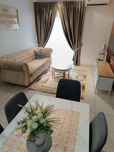 a living room with a couch and a table with chairs at FA Homestay Alanis, Near KLIA in Sepang