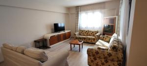 a living room with two couches and a television at Kuşadası'nda Özel Havuzlu Kiralık Büyük Villa in Kusadası