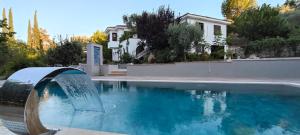a pool with a water fountain in front of a house at Kuşadası'nda Özel Havuzlu Kiralık Büyük Villa in Kusadası
