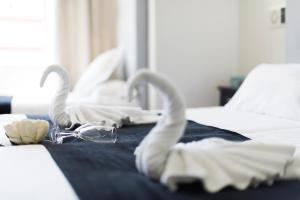 two swan towels on a bed in a hotel room at Hotel Toboso Chaparil in Nerja