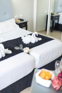 a hotel room with two beds and a tray of food at Hotel Toboso Chaparil in Nerja
