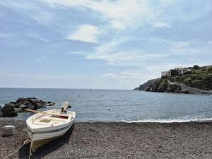 een kleine boot op een strand naast het water bij Bedda Mia - Lipari in Lipari