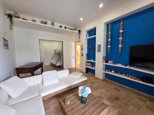 een woonkamer met een witte bank en een blauwe muur bij Bedda Mia - Lipari in Lipari