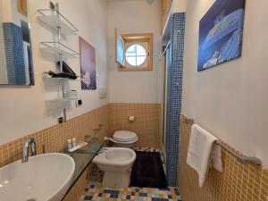 een badkamer met een wastafel, een toilet en een raam bij Bedda Mia - Lipari in Lipari +8 foto's