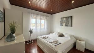 Un dormitorio blanco con una cama y una ventana. en Chloe's Beach House, en A dos Cunhados