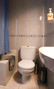 a bathroom with a white toilet and a sink at 5 Apartamentos Cómodos en el Corazón de Baza in Baza