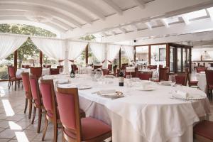 a dining room with white tables and chairs at Giò Hotel in Borgo Celano