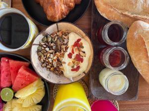 a table topped with a bowl of fruit and bread at Sayamaya - Soft Opening in Gili Islands