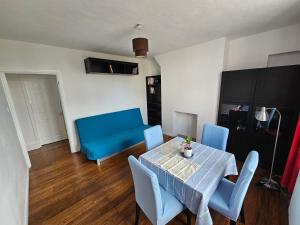 a dining room with a table and blue chairs at Flat in Hammersmith - Close to tube station in London