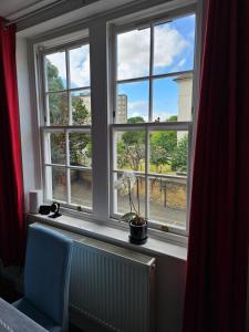 a window with a radiator and a blue chair in front of it at Flat in Hammersmith - Close to tube station in London