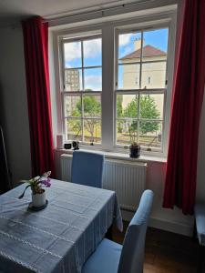 a dining room with a table and two windows at Flat in Hammersmith - Close to tube station in London