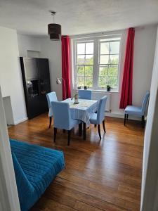 a dining room with a table and chairs and red curtains at Flat in Hammersmith - Close to tube station in London