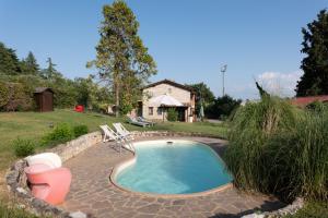 a small swimming pool with two chairs and a house at Botanica in San Sisto