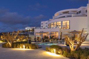 a large white building with a swimming pool at night at Idou Malabata Beach and SPA in Tangier