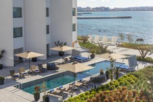 an image of a hotel with a pool and chairs and umbrellas at Idou Malabata Beach and SPA in Tangier