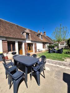 a table and chairs in front of a house at Maison chaleureuse aux portes de Chambord in Maslives