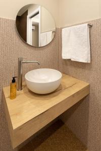 a white sink on a wooden counter in a bathroom at MIRARI Design Rooms in Cala Gonone