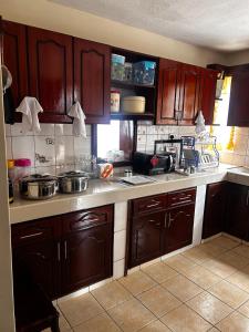 a kitchen with wooden cabinets and a counter top at Axis Guest House in Syokimau