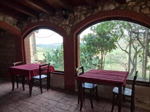 two tables and chairs in a room with a window at Casa Presenza in Santa Elisabetta