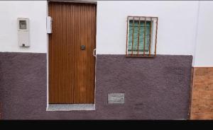 a wooden door on a building with a window at Ocaña in La Puebla de los Infantes
