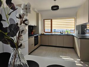 a kitchen with a vase with flowers in it at Stay Inn Green City in Treizeci Decembrie