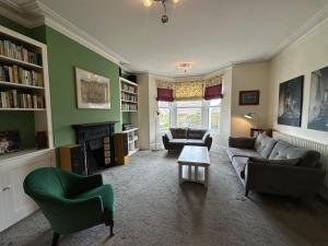 a living room with a couch and chairs and a fireplace at Caroline's House in Swanage
