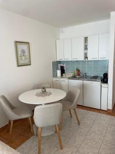 a kitchen with a table and chairs in a room at Studio Apartman Bubi in Nečujam