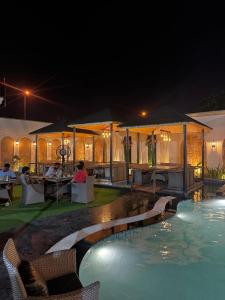 a resort with a swimming pool at night at Kemberly Hotel in Zirakpur