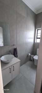 a white bathroom with a sink and a toilet at 154 On Beach - Sandy Point Beach Estate in West Point