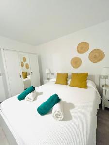 Una cama blanca con toallas verdes y blancas. en Casa Maida, en Tetir