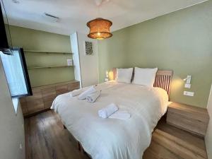 a bedroom with a large white bed with towels on it at LILLEHOSTS 1, Vieux Lille, Newly renovated, Modern & Stylish apartment, perfectly located in Lille