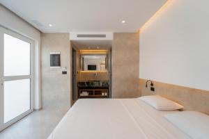 a bedroom with a large white bed and a window at Paloma Seaesta Cabanas in Rhodes Town