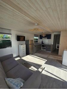 Una sala de estar con un sofá y una cocina. en La Sardine, en Fréjus