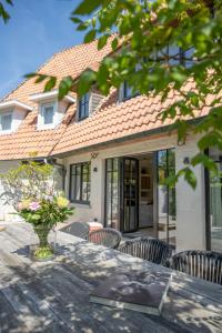 a table with chairs in front of a house at NEW Family Chic Design, Comfort & Outdoor Living - Free Parking Wifi in Knokke-Heist