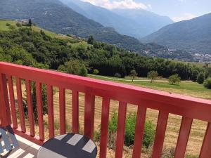 a red bench on a balcony with a view of mountains at Chambre - Sdb Privative - Super Vue in Pallud