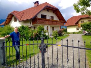 un hombre parado frente a una valla delante de una casa en Apartment Studio Van Bakel Gerard, en Bled