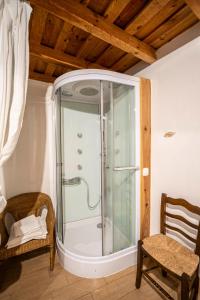 a glass shower in a room with a chair at Casa Rural La Barquilla in Acebo